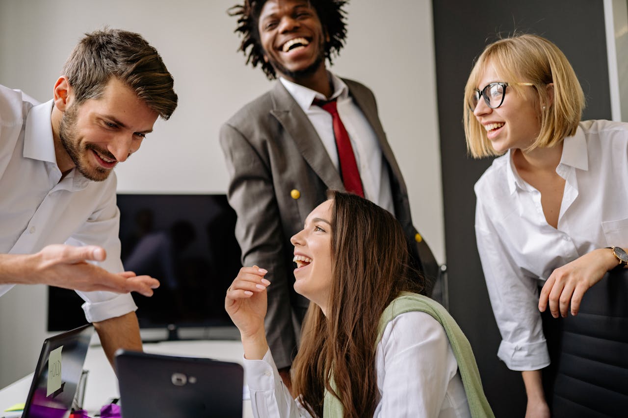 A diverse group of professionals enjoying a light-hearted moment in the office.